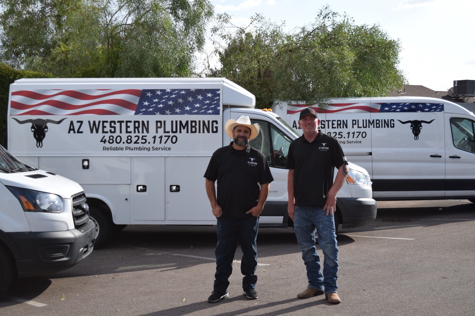 Two AZ Western Plumbing & Air team members standing in front of company service vehicles