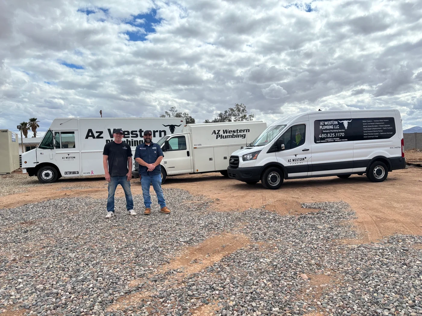 Two AZ Western team members in front of three branded plumbing service vehicles