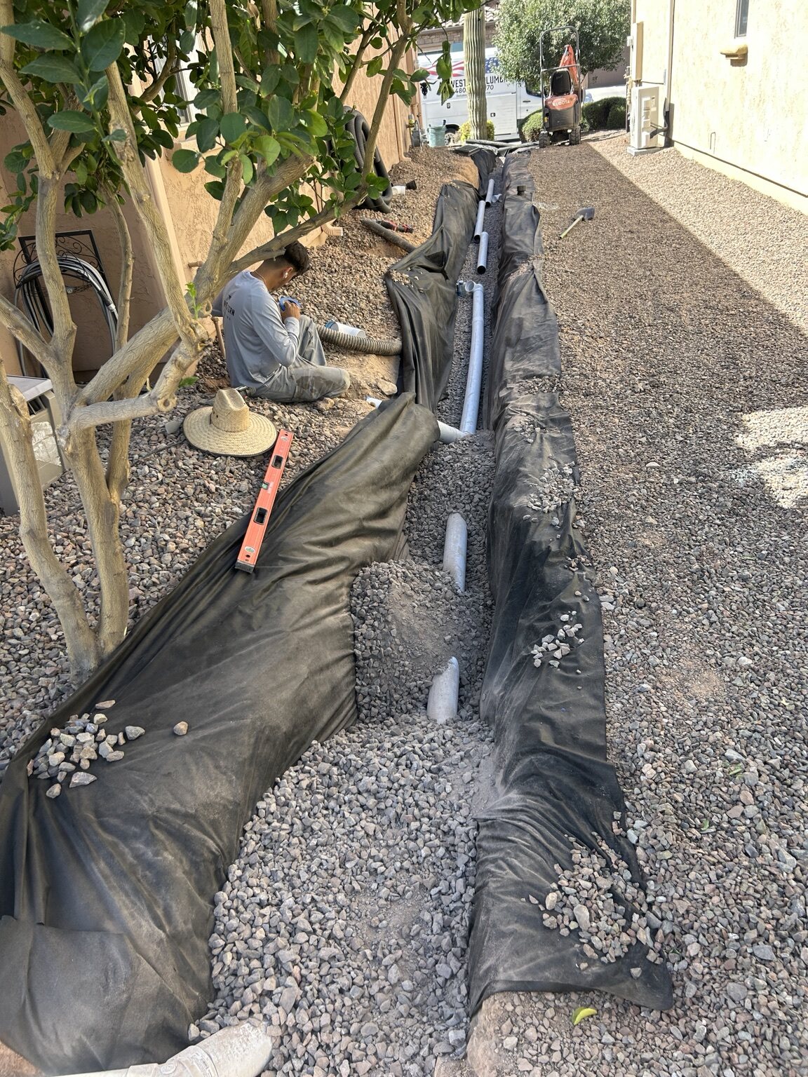 AZ Western team member working beside an open trench and pipe outside a home