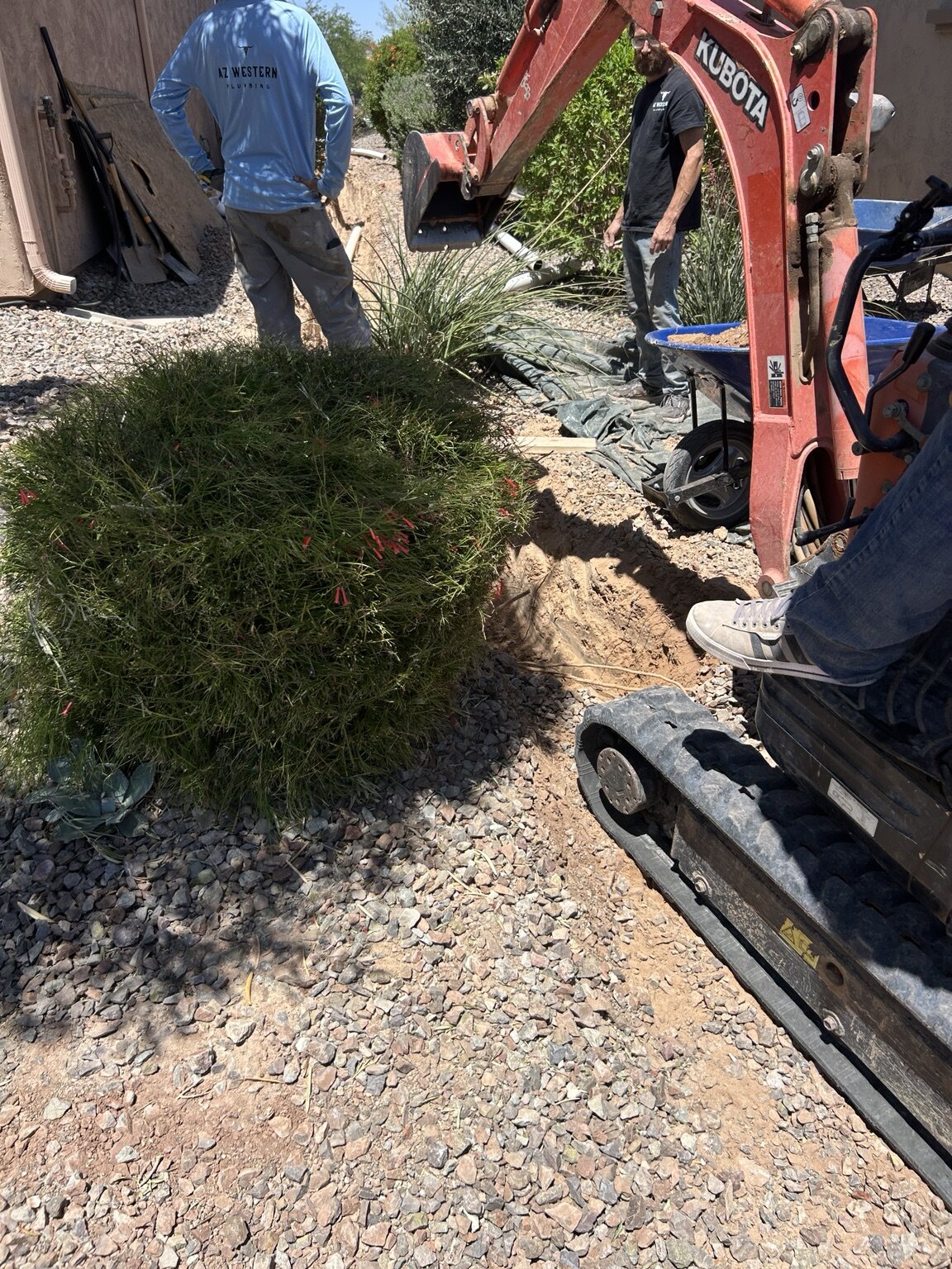 Two AZ Western crew members near a small excavator at a residential job