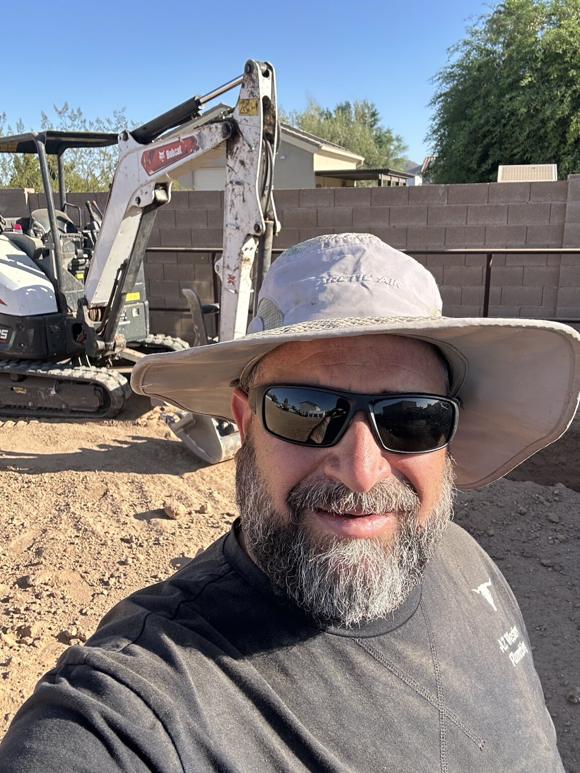 AZ Western crew member smiling in front of excavation equipment