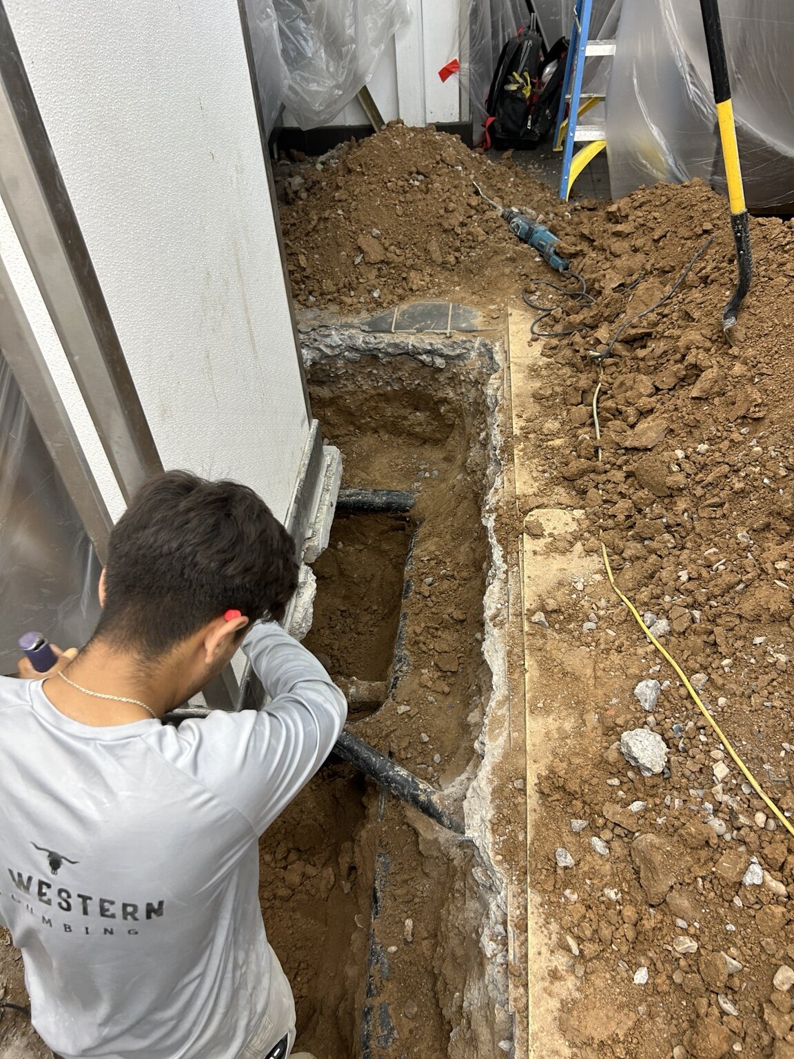 AZ Western crew member working on exposed underground piping inside a building