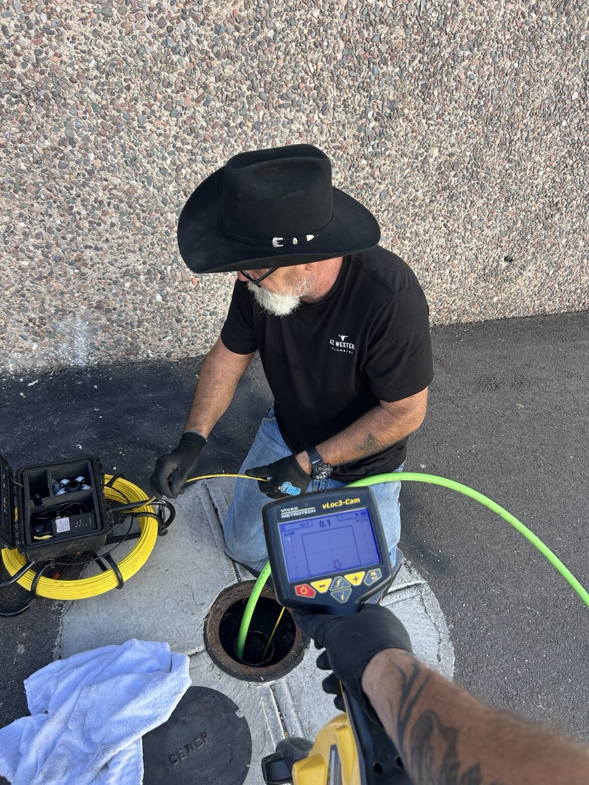 AZ Western technician using a camera inspection system at a ground access opening