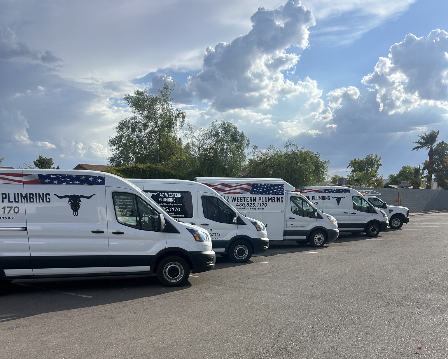 AZ Western Plumbing & Air service vehicles lined up beneath an Arizona sky