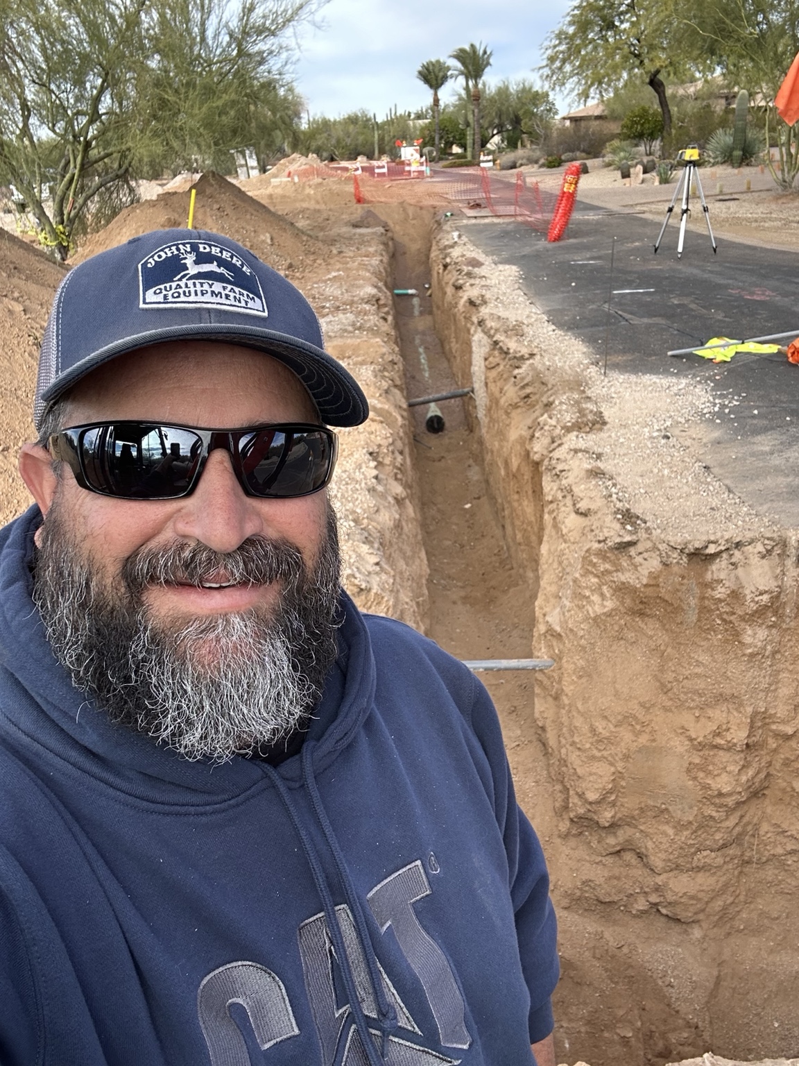 AZ Western crew member standing beside a deep utility trench at a residential street project
