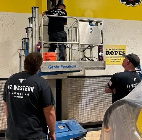 AZ Western plumbers working together around a lift