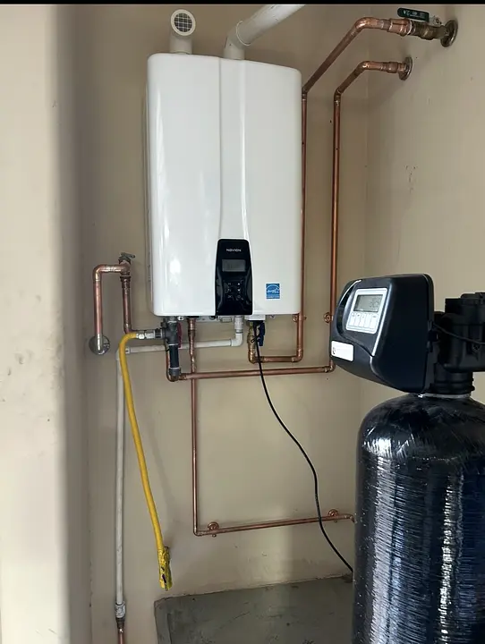 Wall-mounted tankless water heater with copper piping and water treatment equipment