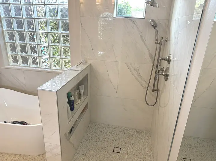 Finished shower with tile, glass panel, and glass-block window